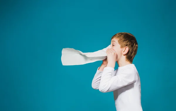 Ragazzo in abiti bianchi comico soffiando il naso — Foto Stock