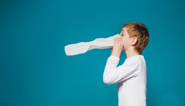 白い服を着て彼の鼻を吹く少年 — ストック写真