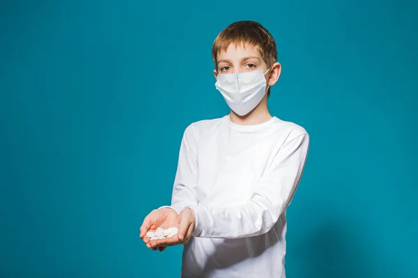 Junge in weißer Schutzmaske hält Pillen in der Hand — Stockfoto