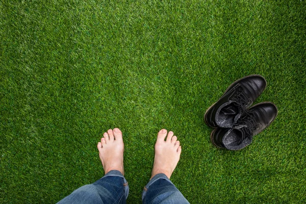 Mens feet resting on green grass — Stock Photo, Image