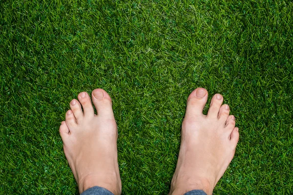 Mens fötter står på gräset på nära håll — Stockfoto