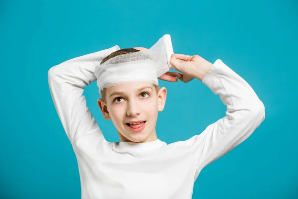 Gelukkige jongen taping omhoog verband op zijn hoofd — Stockfoto