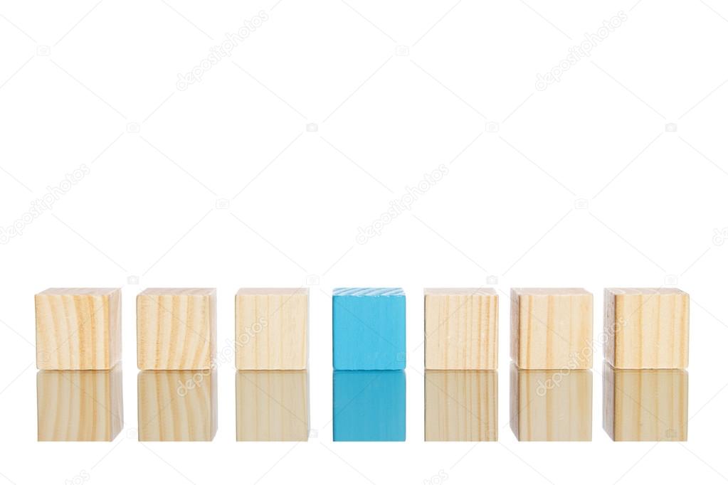 wooden blocks standing in line with blue one in the centre