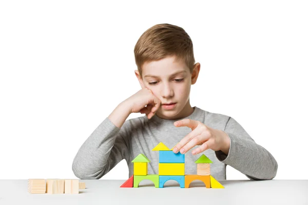 Retrato de uma casa de construção menino feito de blocos de madeira — Fotografia de Stock