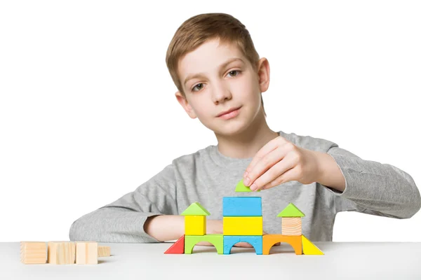 Ritratto di un ragazzo che costruisce una casa di blocchi di legno — Foto Stock