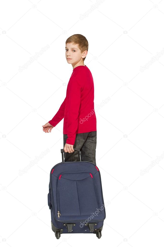 Boy holding travel bag walking away isolated on white