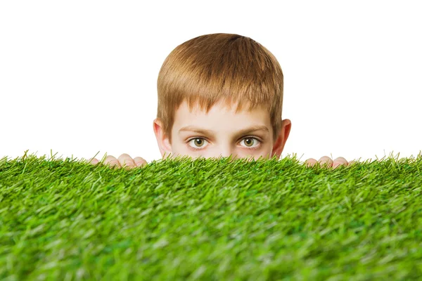 Retrato de um menino espreitando pela grama — Fotografia de Stock