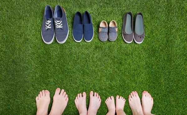 Gambe e scarpe di famiglia in piedi su erba verde — Foto Stock