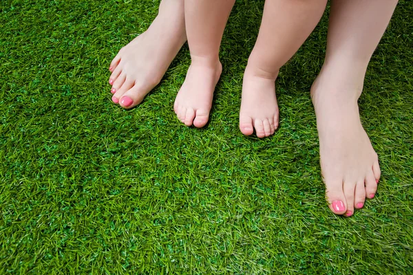 Mutter und kleine Babybeine stehen auf Gras — Stockfoto