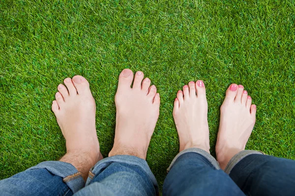 Pernas de casal de pé juntos na grama — Fotografia de Stock