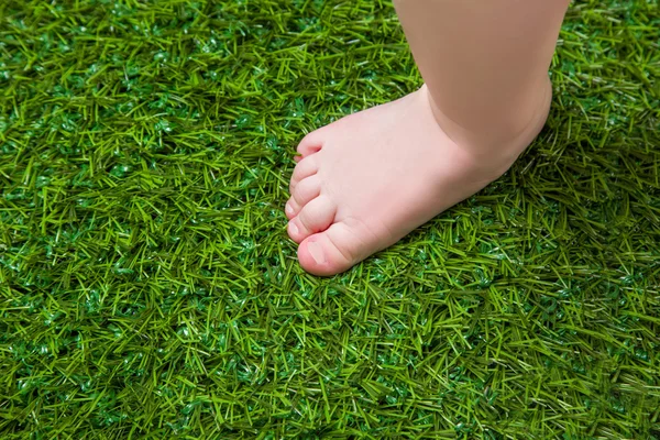 Baby holé nohy stojící na zelené trávě — Stock fotografie