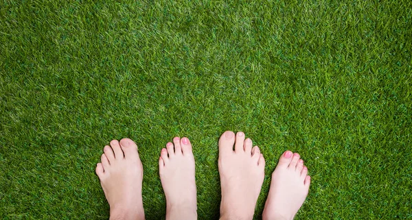 Couple mixed legs standing close together on grass — Stock Photo, Image