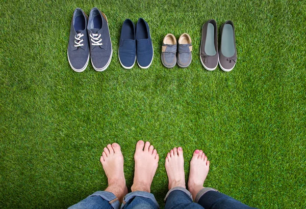 Мужчины и женщины ноги в обуви стоя на траве — стоковое фото