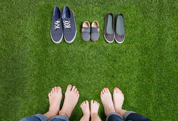 Pernas de família em jeans e sapatos de pé na grama — Fotografia de Stock