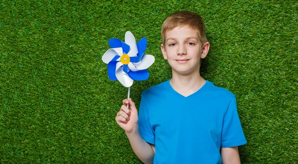 Porträtt av leende pojke anläggning pinwheel — Stockfoto