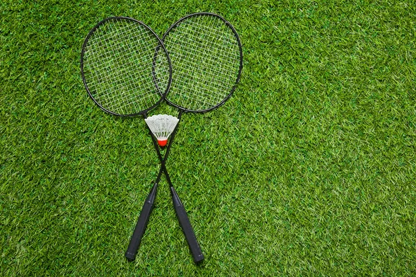 Badmintonové rakety s zkopán na trávě — Stock fotografie