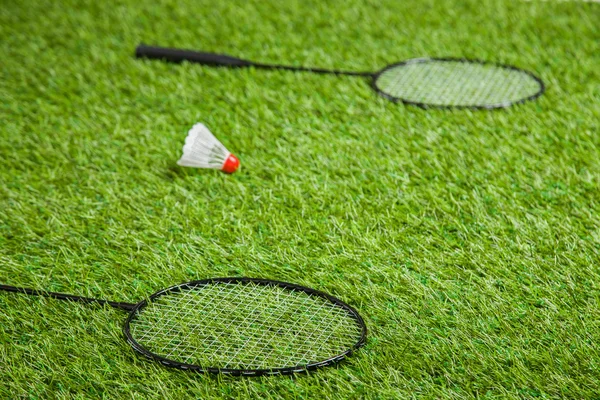 Dois badminton raquetes deitado com branco shuttlecock — Fotografia de Stock