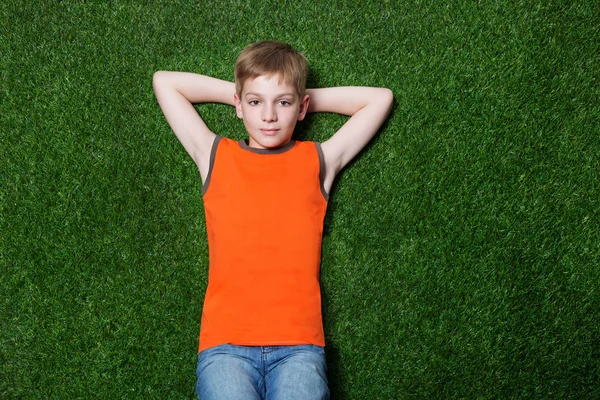 躺在绿色草地上的那个男孩 — 图库照片