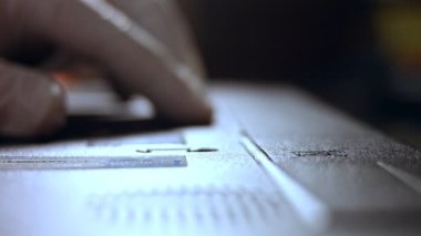Defter bataryasını değiştiren teknisyenin yakın plan fotoğrafı.