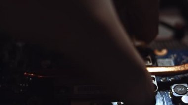 Soğutma sistemini kaldıran teknisyenlere yakın çekim. İşlemci ve eski ve kuru termal yapıştırıcı