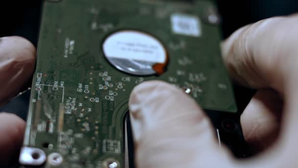 Primer plano de un técnico analizando el disco duro de un portátil. Lento. — Vídeo de stock