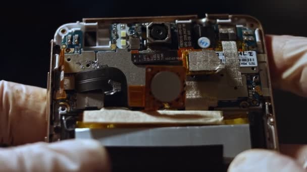 Close-up de telefone celular desmontado, mostrando detalhes da placa-mãe, microtecnologias — Vídeo de Stock