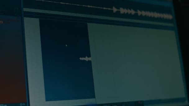 Primer plano del monitor que muestra el proceso de grabación y edición de sonidos. Pantalla de computadora de un ingeniero. Gráficos nivel de volumen. Mala luz en estudio de grabación — Vídeos de Stock