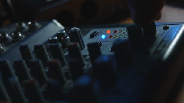 Κοντινό πλάνο των δακτύλων ρυθμίζοντας την κονσόλα μίξης ήχου. Κονσόλα μίξερ για παραγωγή ήχου σε στούντιο ηχογράφησης. Κακό φως — Αρχείο Βίντεο