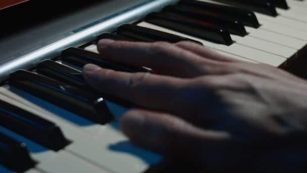 Manos tocando en teclado electrónico de piano con. Concepto de estudio de grabación musical. Músico produciendo canción en el estudio. Proceso de grabación de canciones. Mala luz — Vídeos de Stock