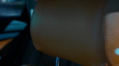 Arabanın ön koltuğunun deri başlığının yakın çekimi. Güzel deri araba iç tasarımı. Araba ayrıntıları sunumu yavaş çekimde