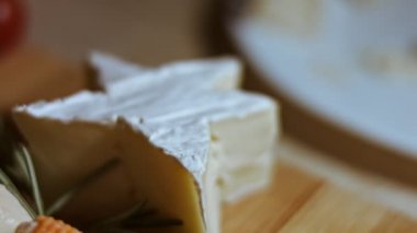 Tahta kesme tahtasında yumuşak peynirli peynir. Lezzetli bir parça beyaz küflü peynir ve yıldız şeklinde yumuşak bir doku. Makro görünüm