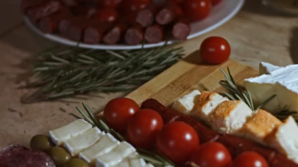 Pose plate de fromage et plateau de viande. Tranches de fromage, saucisse fumée, tomates, olives et rozmarine disposées en forme d'arbre de Noël. Nourriture pour Noël. Mouvement lent — Video