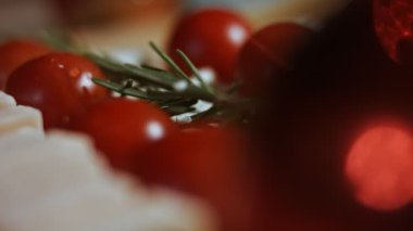 Peynir ve domates düzlüğü. Noel ağacı şeklinde dizilmiş peynir, domates ve rozmarin dilimleri. Noel tatili için yemek. Makro görünüm