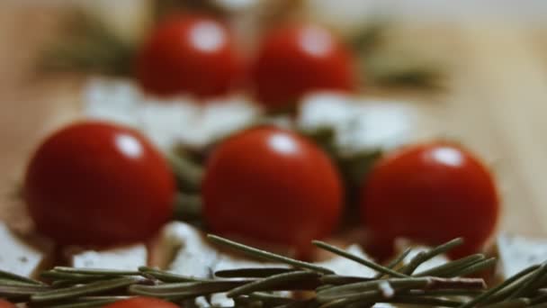 Plat leggen van kaas en tomaten. Stukjes kaas, tomaten en rozmarin in de vorm van een kerstboom. Eten voor kerstvakantie. Macro-weergave — Stockvideo