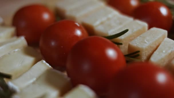 Plat leggen van kaas en tomaten. Stukjes kaas, tomaten en rozmarin in de vorm van een kerstboom. Eten voor kerstvakantie. Macro-weergave — Stockvideo