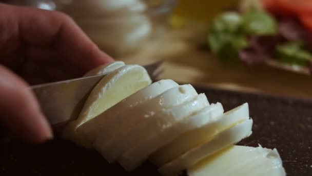 Felvágni egy mozarella labdát egy vágóasztalra. Makronézet — Stock videók