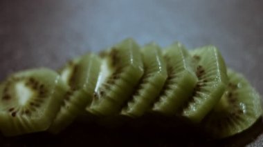 Siyah mermer kesme tahtasında taze kivi dilimleri. Makro görünüm