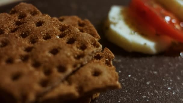 Caprese - italienisches Nationalgericht. In Scheiben geschnittene Tomaten und Mozarella in Form von Weihnachtsbonbons. Serviert mit Basilikum und Olivenöl. Zeitlupe. Makrosicht — Stockvideo