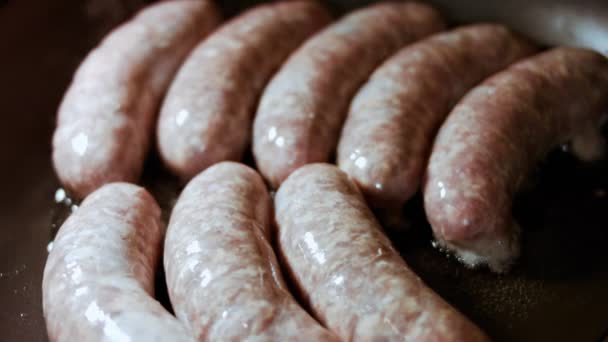 Primo piano di cottura delle salsicce in padella nera con olio. Salsicce fritte in olio di girasole caldo. — Video Stock