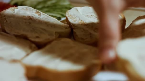Руки розкладають майонез на хлібному маслі. святкова їжа — стокове відео