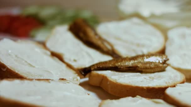 Hands spread mayonnaise on bread butter. We take the sprats wit toast. Holiday food — Stock Video
