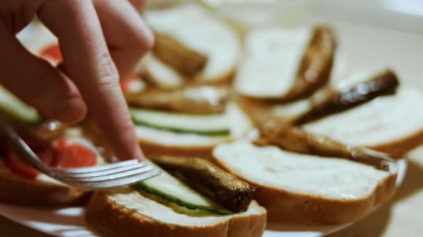 Hands spread tomatoes and cucumbers on bread butter. We take the sprats wit toast. Holiday food — Stock Footage Hands spread tomatoes and cucumbers on bread butter. We take the sprats wit toast. Holiday food Stock Footage