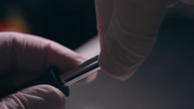 Yakın plan. Tornavida, bilgisayarın sabit diskindeki vidayı söküyor. Erkek eller bilgisayar sabit diskindeki vidayı tornavidayla büker. Bilgisayar sabit diskini onarma ustasının elleri HDD