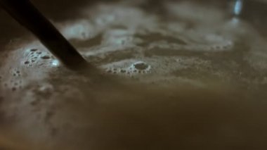 Gnocci tuzlu suda pişiriliyor, hoş bir atmosfer. 4K Video. Düğümleri kaşıkla karıştır.