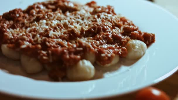 Gnocci with tomato sauce being sprinkled with Parmesan. Mix with a spoon. Pleasant atmosphere. 4k Video. Slow Motion. — Stock Video