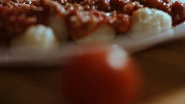 Gnocci με σάλτσα ντομάτας που πασπαλίζεται με παρμεζάνα. Ανακατεύουμε με ένα κουτάλι. Ευχάριστη ατμόσφαιρα. Βίντεο 4k. Αργή κίνηση. — Αρχείο Βίντεο