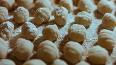 Şef, ev yapımı gnocchi hazırlamak için patates hamuru ruloları kesiyor. 4k Video.