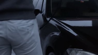 Araba yıkama servisi. Köpüğü yüksek basınçlı suyla durulamak ve yıkamak. Kiraz rengi lüks araba. Güzel bir ortam. 4K video