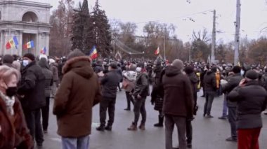 Chisinau, Moldova Cumhuriyeti - 06 Aralık 2020: Moldova halkı barışçıl bir siyasi gösteri için toplanıyor, hükümete karşı protesto ediyor, ulusal bayraklar taşıyor, koruyucu yüz takıyor