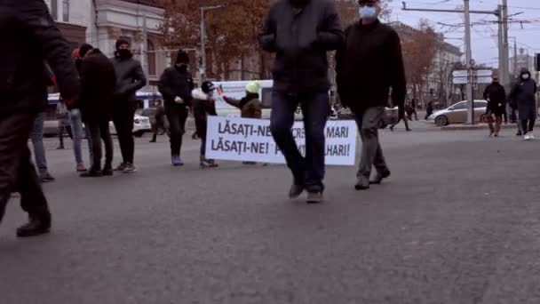 Chisinau, Republic of Moldova - December 06, 2020: Moldovan people holding board with slogan on a peaceful political demonstration, protesting against the government, wearing protective face masks — Stock Video